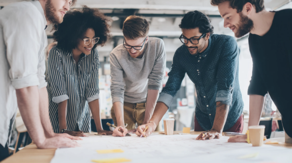 Creative team brainstorming ideas using a printed brand guide.
